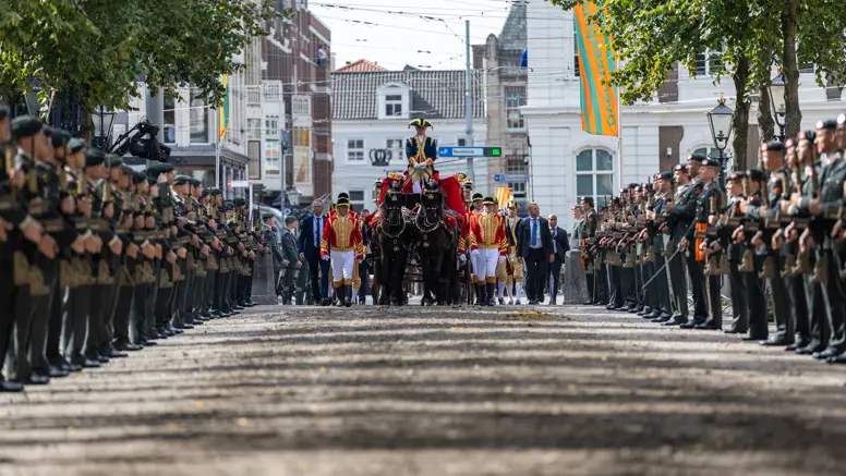 Gouden Koets rijdt door haag militairen 