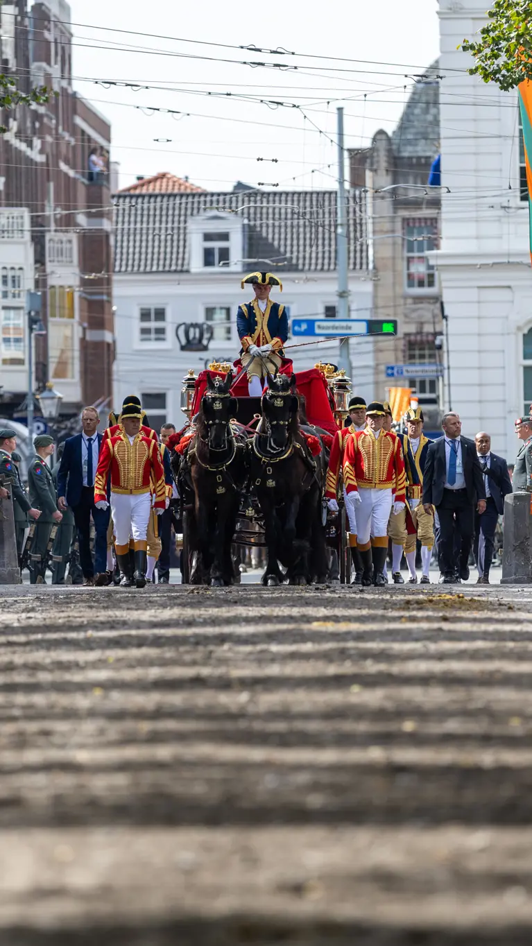 Gouden Koets rijdt door haag militairen 