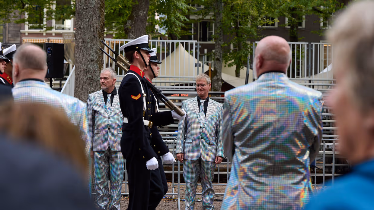 Publiek met glanzend zilveren pakken.