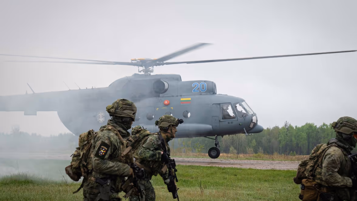 Militairen met op de achtergrond een heli.