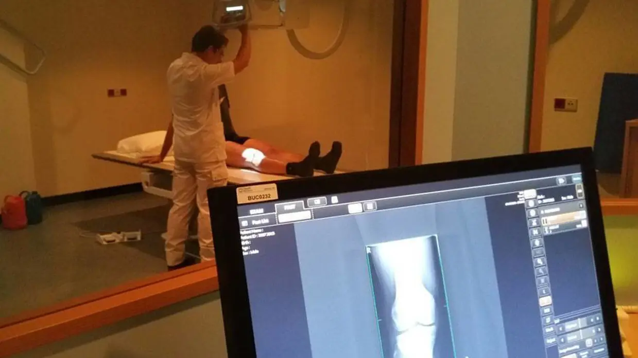 Een laborant van radiologie maakt röntgenfoto van knie.