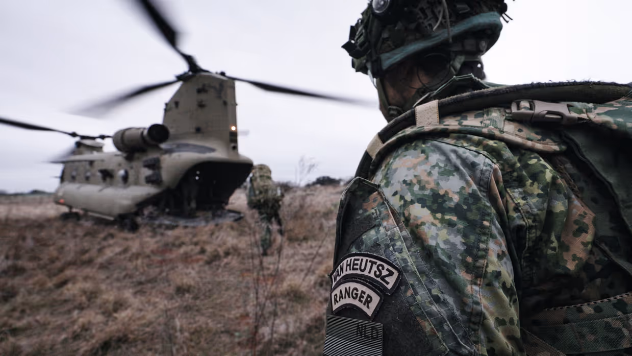 Militairen in het veld stijgen een Chinook in. Op de voorgrond een militair met op zijn mouw de tekst ‘Van Heutsz; Ranger’.