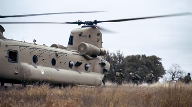 Militairen verlaten via de achterklep een Chinook in het veld.