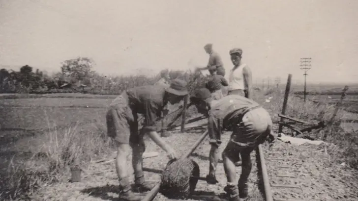 Mannen werken aan de spoorlijn in Indonesië.