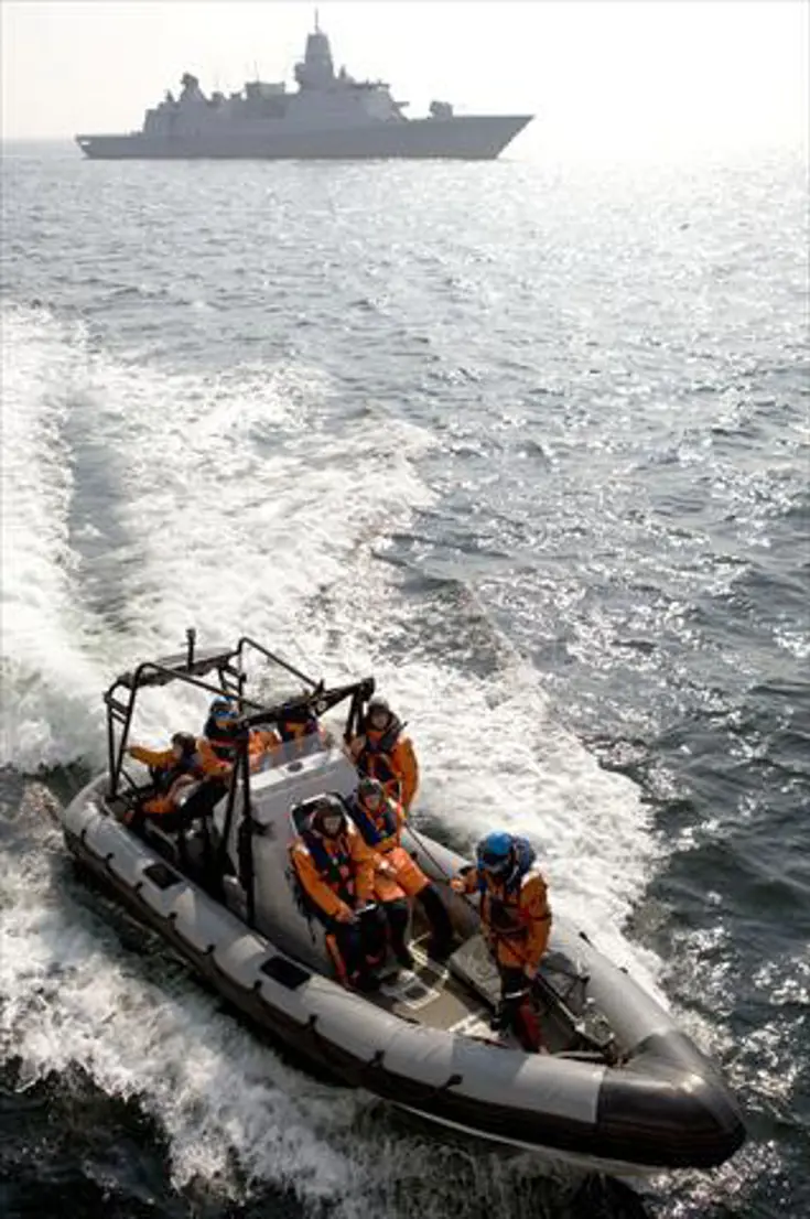 Op de voorgrond een RHIB met op de achtergrond een schip.