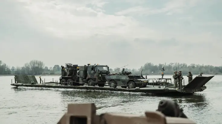 Ponton met vrachtwagen steekt rivier over.