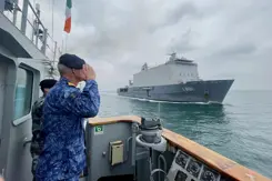 Warnaar saat op het Ierse schip en groet zijn schip dat voorbij vaart.