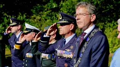Vier militairen op rij, onder wie luitenant-generaal Steur, brengen de militaire eregroet. Daarnaast staat de Eindhovense burgemeester Jeroen Dijsselbloem.