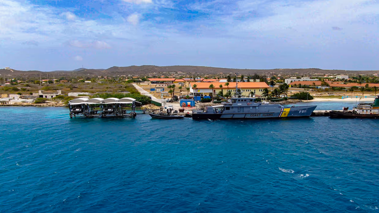 Een vijftal mannen poseert op straat in trainingstenue. 
