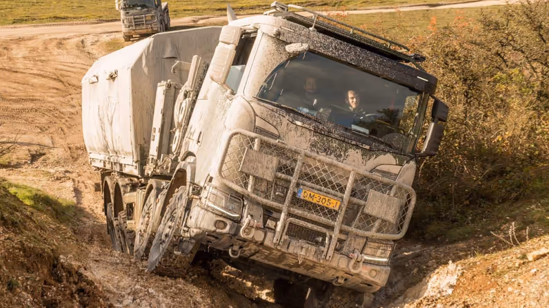 Een tweetal vrachtwagens in het terrein.