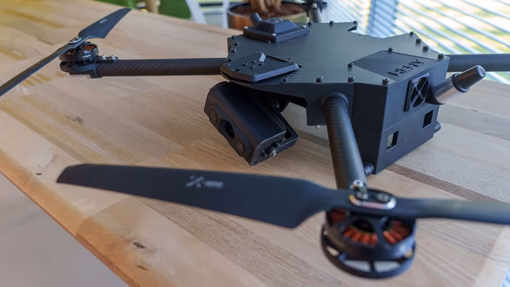 Innovatief apparaat met soort propellers op houten tafel.