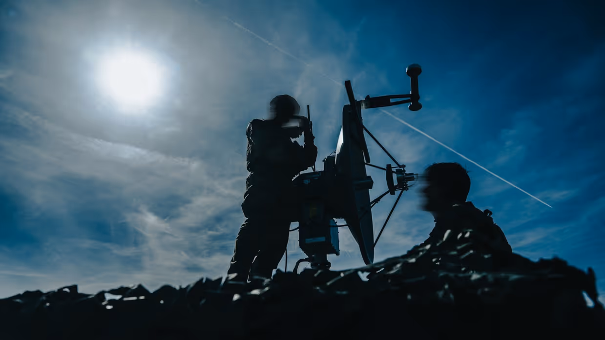 Silhouetten van militairen met een wapen.