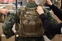 Militair doet kogel- en scherfwerend vest om.