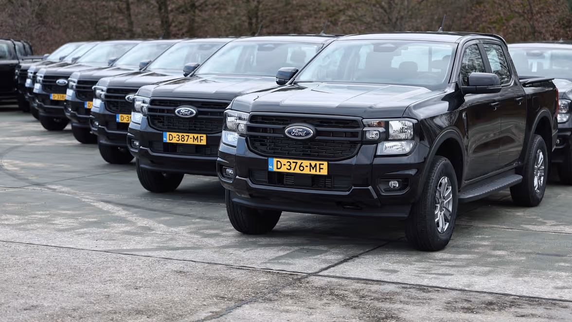 Op rij geparkeerde zwarte vierwiel-aangedreven voertuigen.