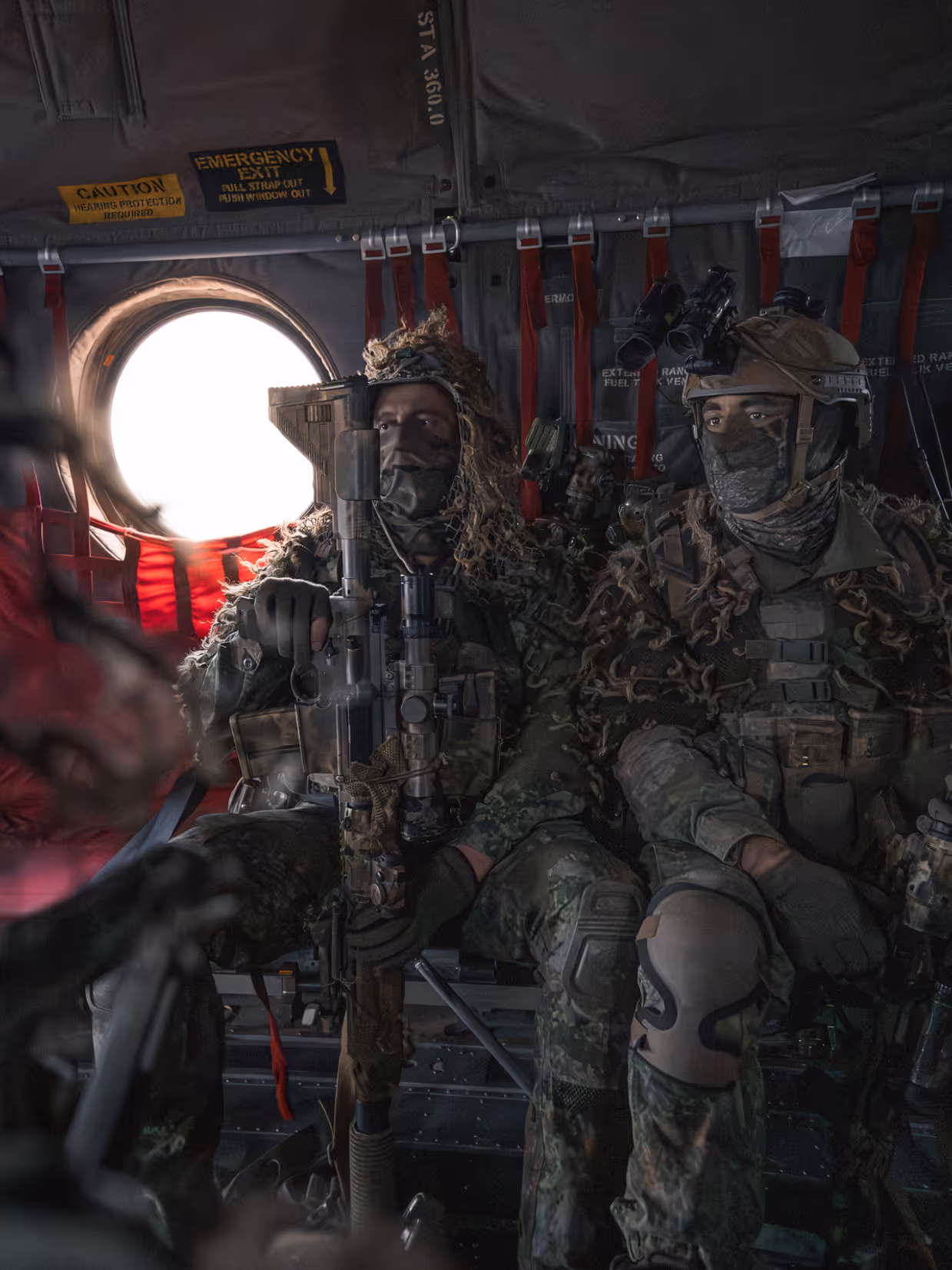  Twee militairen met wapens zittend in een Chinook.