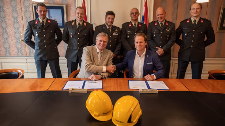 Staatssecretaris Gijs Tuinman geeft Heijmans een hand nadat ze de overeenkomst hebben getekend. 