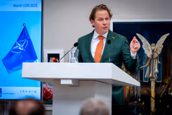 Staatssecretaris Gijs Tuinman staat achter een katheder.