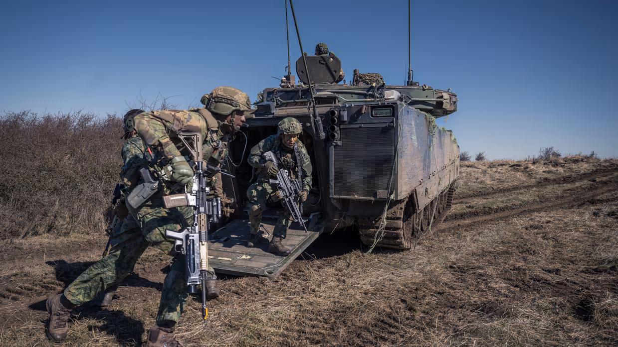 Militairen stappen uit gevechtsvoertuig.