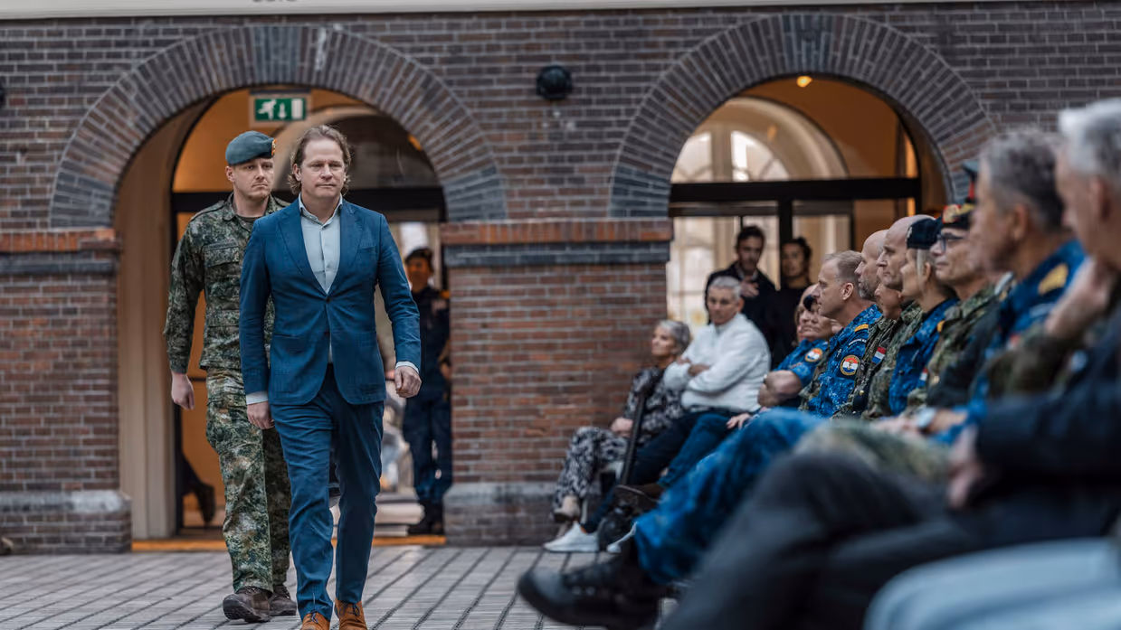 De staatssecretaris loopt langs de genodigden. 