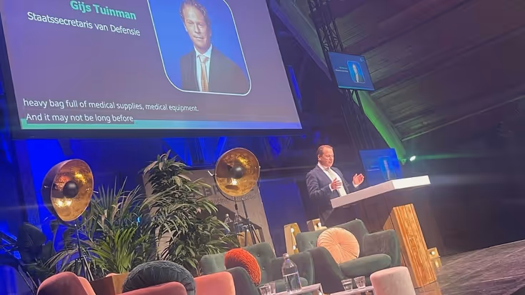 De staatssecretaris aan het woord tijdens een congres.