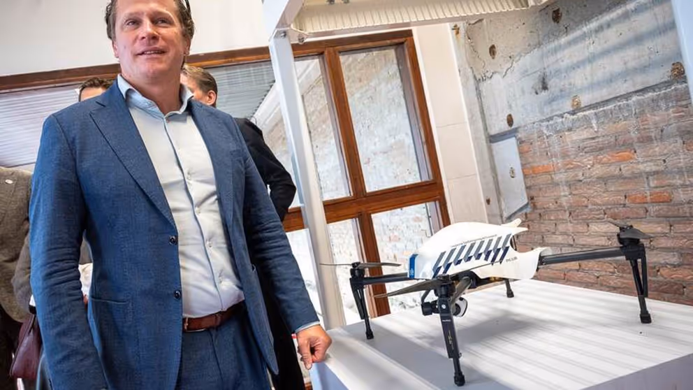 Staatssecretaris Tuinman staat naast een tentoongestelde drone.