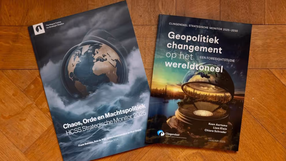2 Strategische Monitor-rapporten van Instituut Clingendael en The Hague Centre for Strategic Studies liggen op een houten tafel.