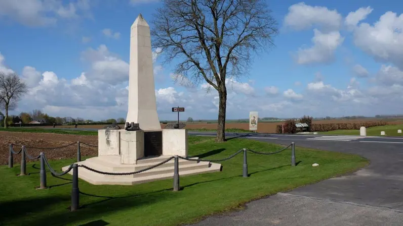 Een hoog wit monument met een obelisk, omringd door groen gras, bomen en een heldere hemel. (Foto: Tripadvisor)