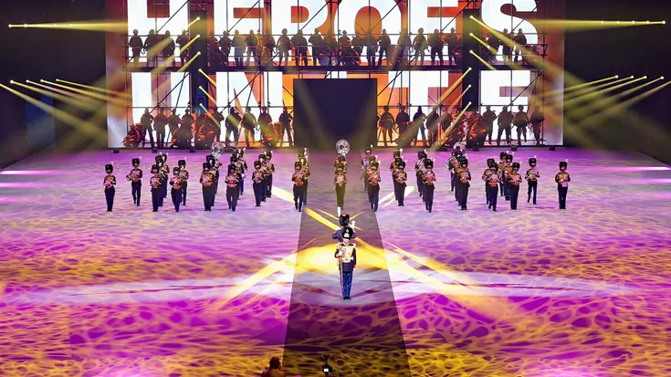 De KMKJWF tijdens de Nationale Taptoe. Op de achtergrond het woord: "heroes".