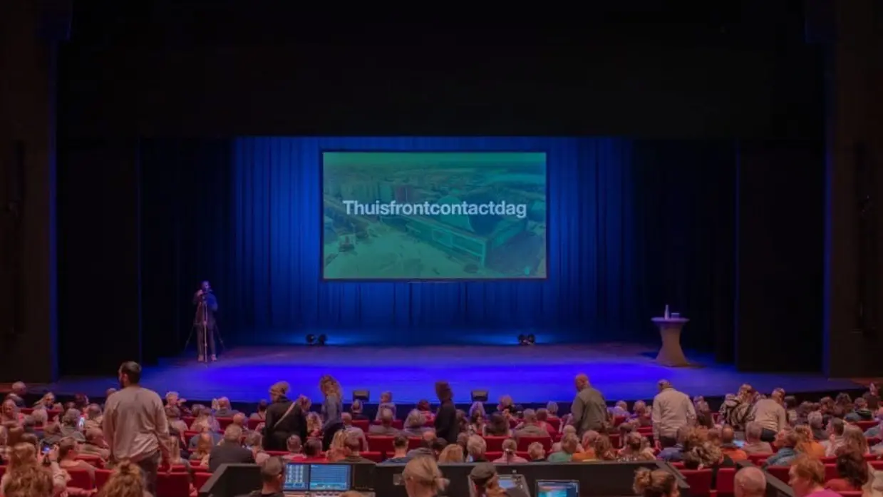 Een bioscoopzaal vol met mensen. Op het beeld de tekst: thuisfrontcontactdag.