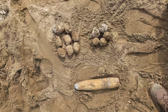 Projectielen liggen in het zand. 