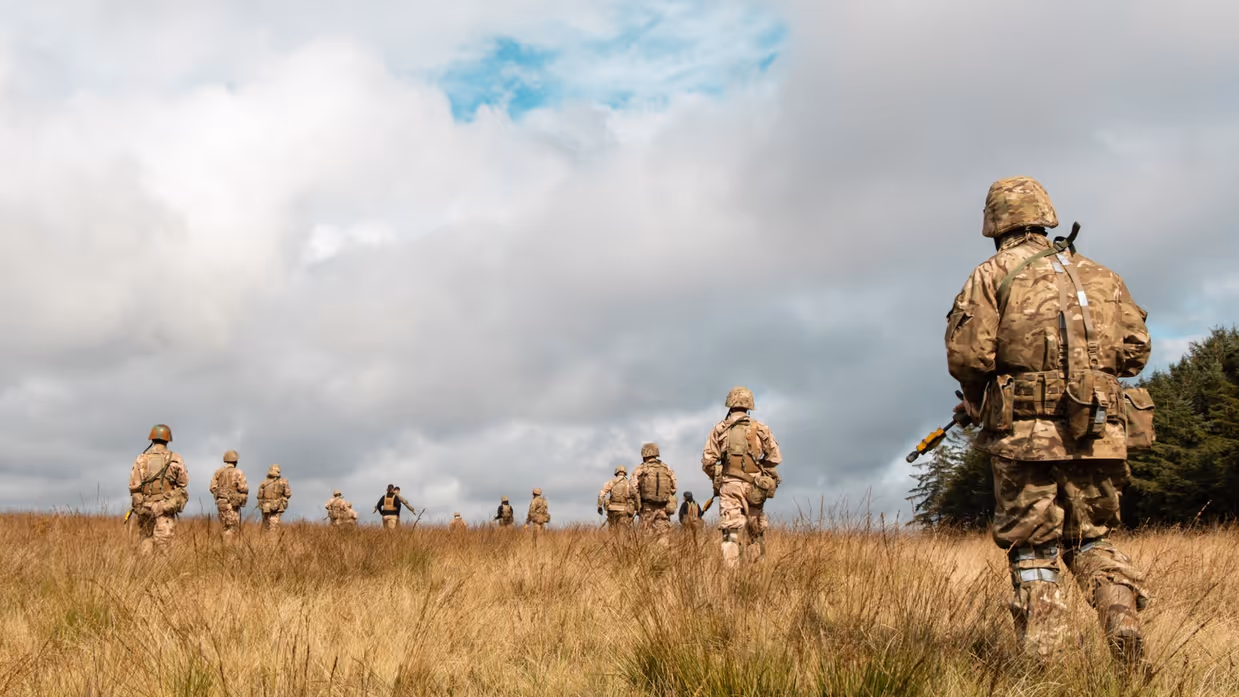 Militairen in het veld op de rug gezien.