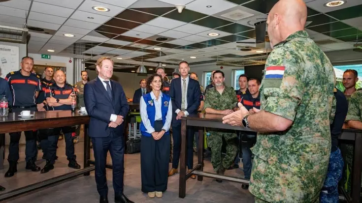 Van Weel en Lahbib tussen de brandweer en militairen.  Van Weel (links) en Lahbib (rechts) tussen de brandweer en militairen.