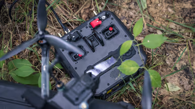 Dronecontroller en drone liggen gereed voor inzet in het terrein. 