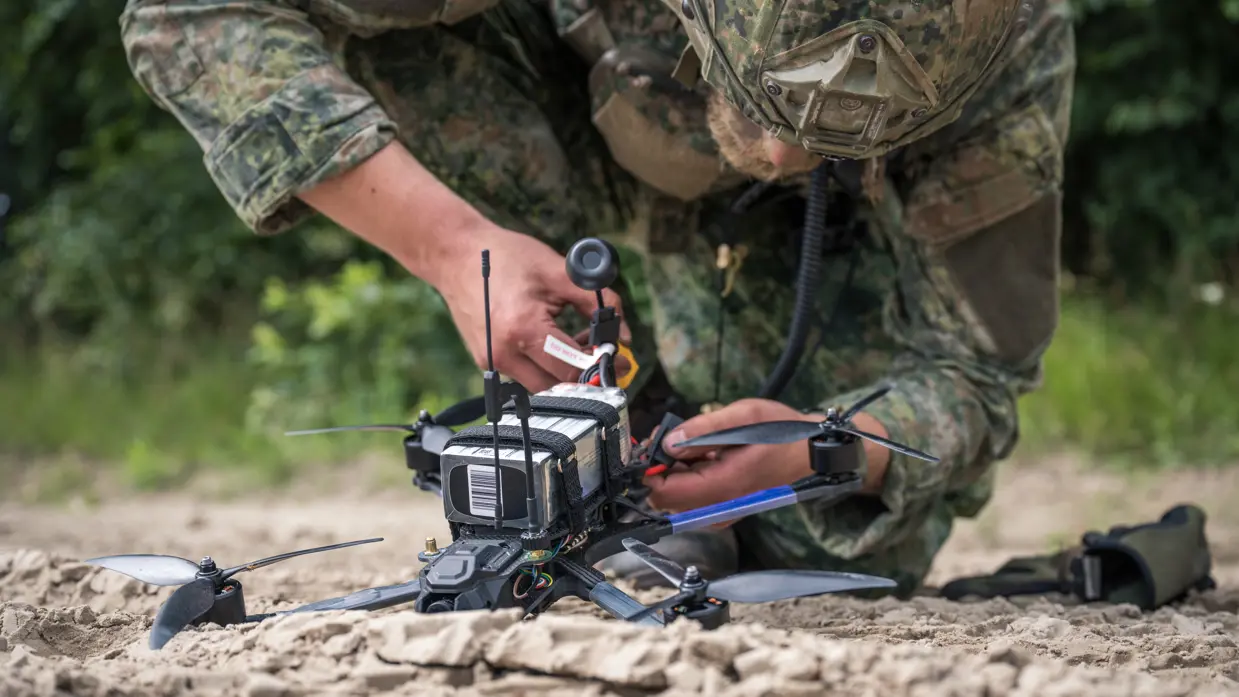 Een militair sleutelt aan een drone. 