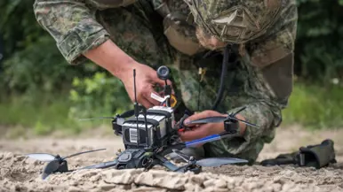Een militair sleutelt aan een drone. 
