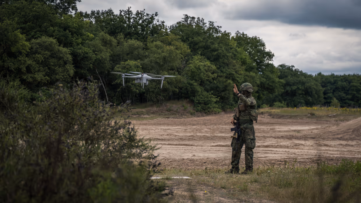 Militair begeleidt een drone tijdens inzet in het veld. 