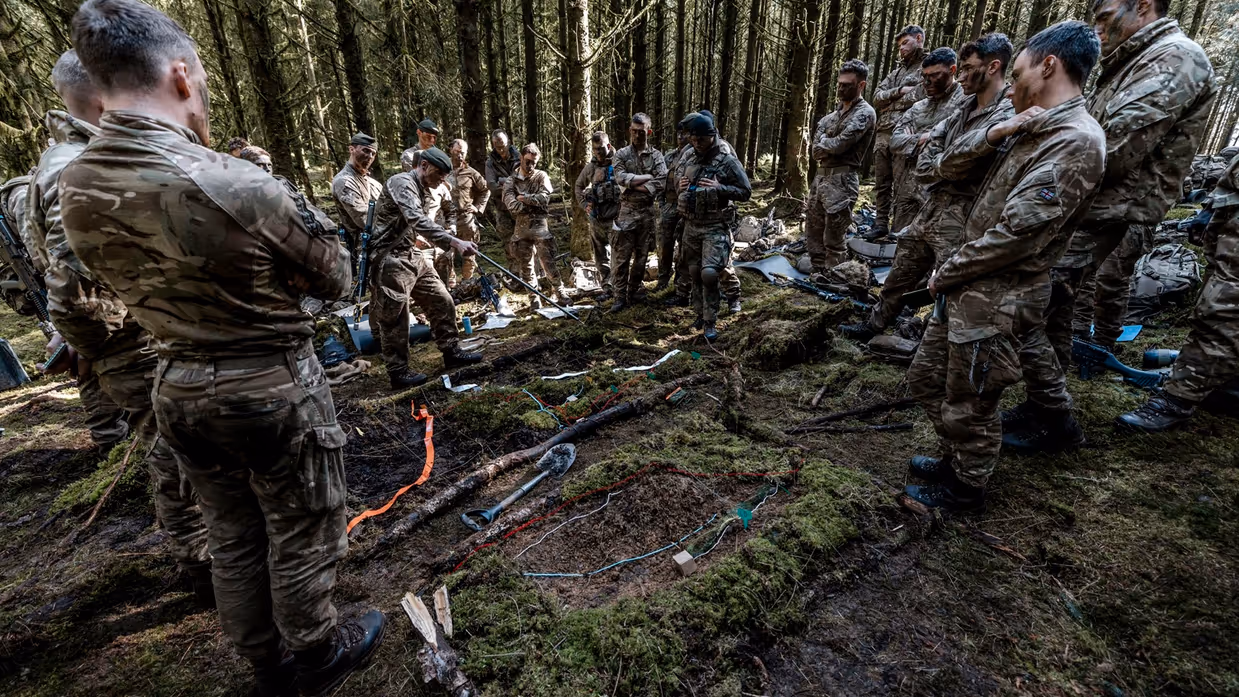 Een groep mariniers krijgt instructies in het veld.