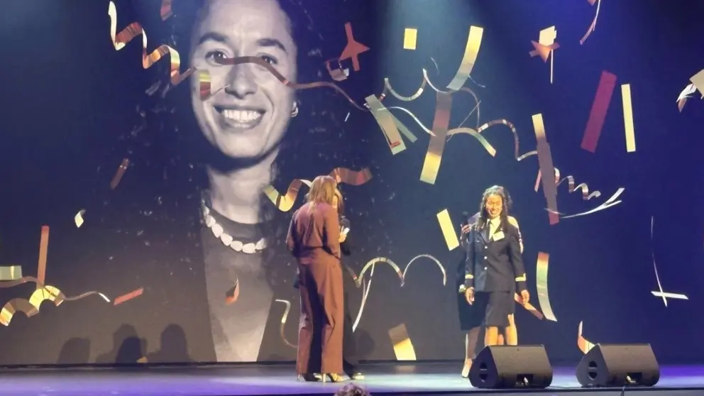 Maite Snel loopt het podium op om haar prijs in ontvangst te nemen.