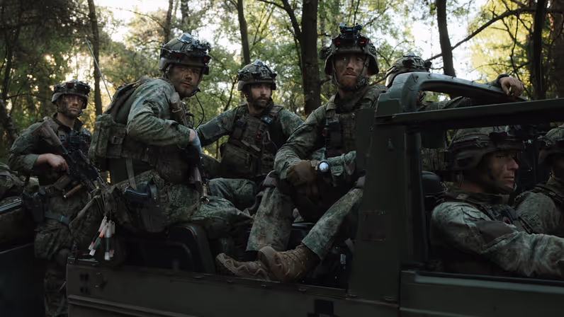Militairen van 11 Luchtmobiele Brigade zitten met gevechtsuitrusting in een voertuig.