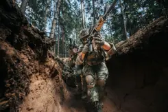 Gewapende militairen in een loopgraaf.