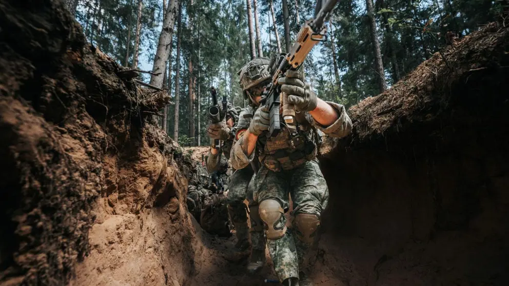 Gewapende militairen in een loopgraaf.