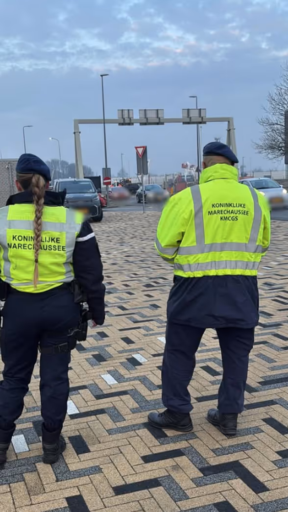 Twee marechaussees op de rug gezien tijdens een verkeerscontrole