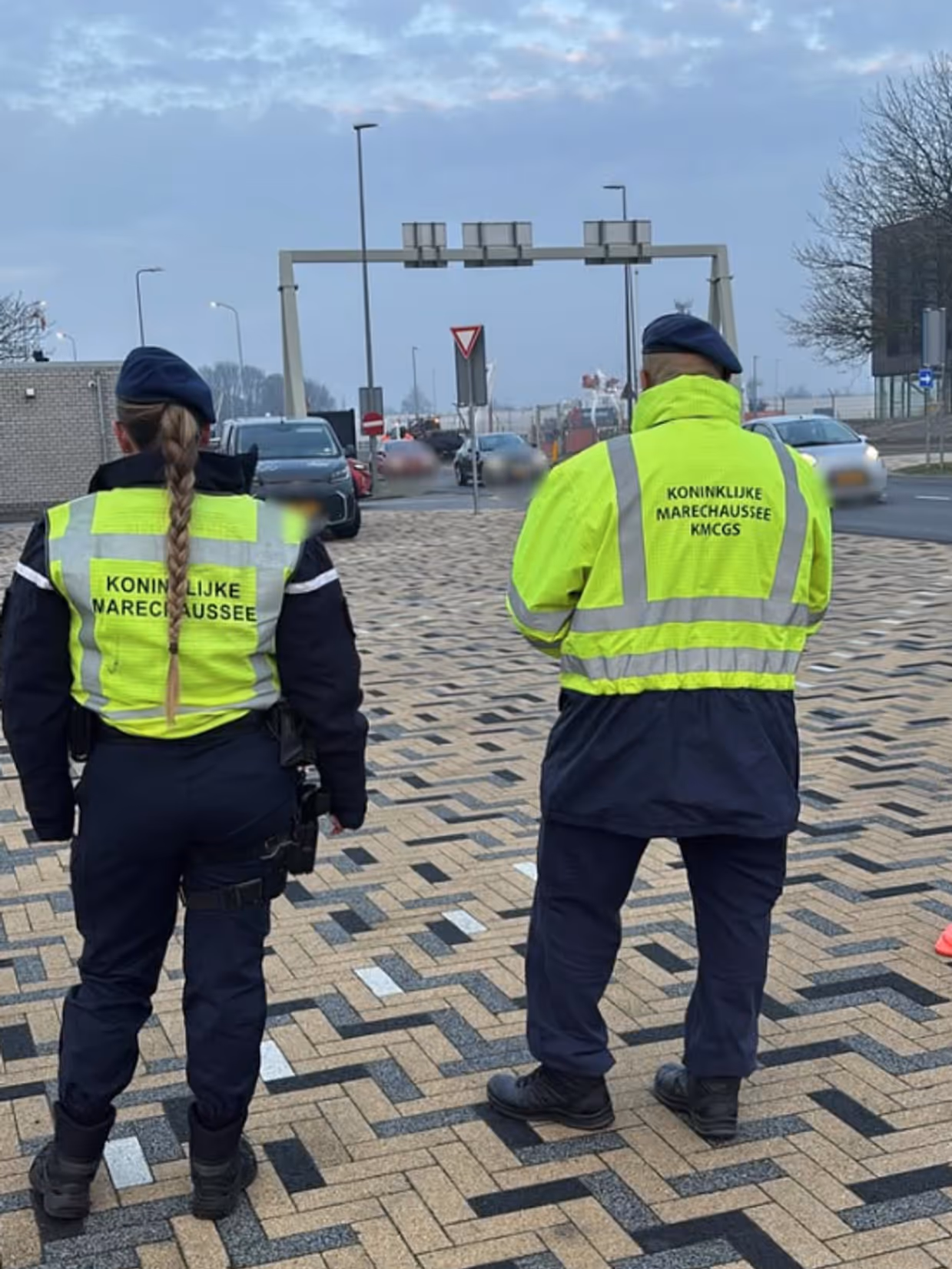 Twee marechaussees op de rug gezien tijdens een verkeerscontrole