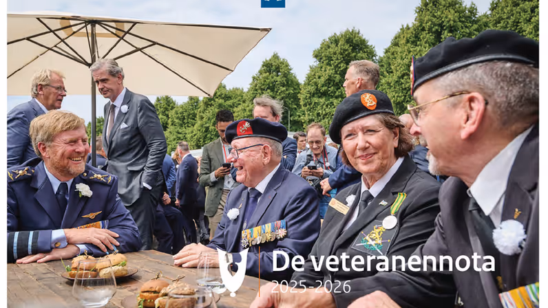 Drie veteranen in informele sfeer aan een buitentafel in gesprek met koning Willem-Alexander. Op de achtergrond bomen en pratende mensen. Over de foto heen staat de tekst ‘De veteranennota 2025-2026’.