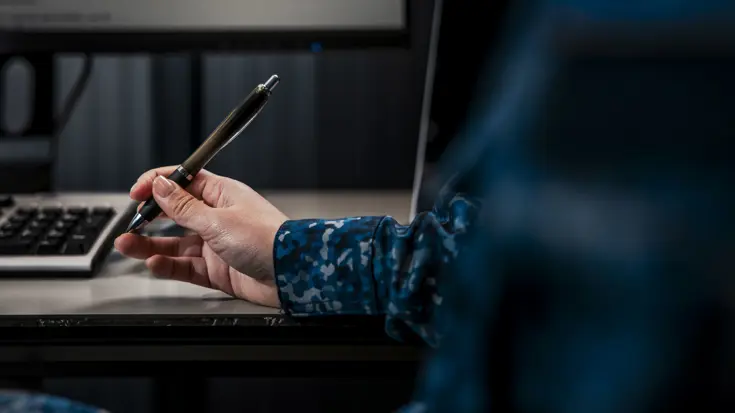Close-up van een hand die een pen vasthoudt.