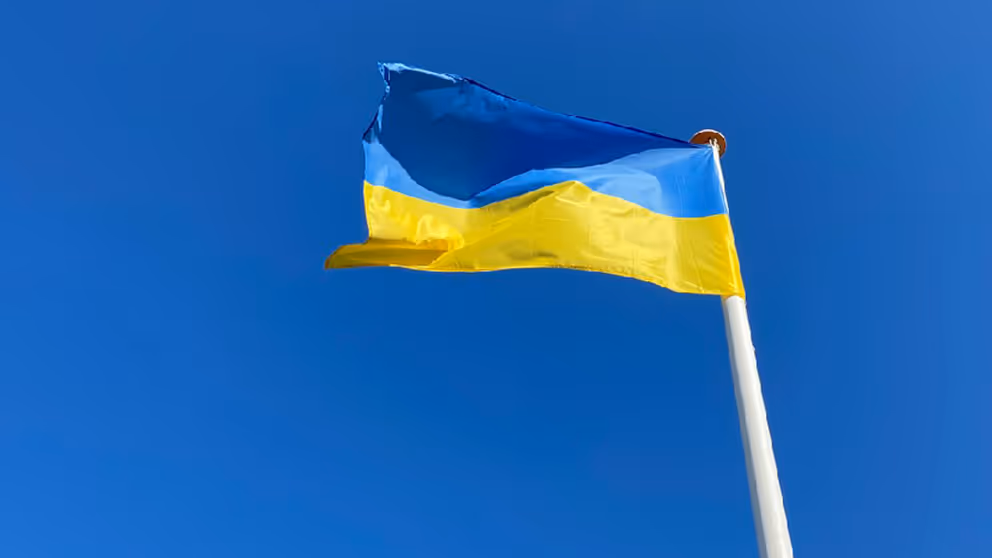 Wapperende Oekraïense vlag met blauwe lucht erachter.