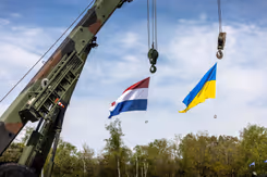 Een Nederlandse en een Oekraïense vlag hangen aan een kraan.