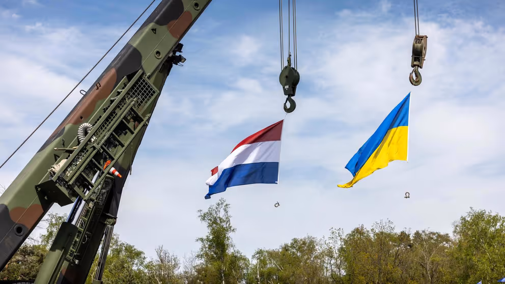 Een Nederlandse en een Oekraïense vlag hangen aan een kraan.