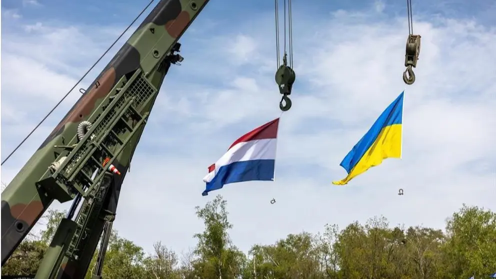 De vlaggen van Nederland en Oekraïne hangen aan een kraan. 