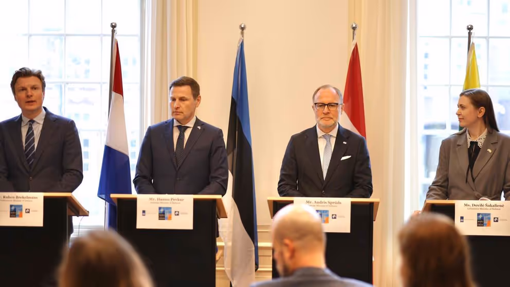 Ministers van Defensie Ruben Brekelmans, Hanno Pevkur,  Andris Sprūds en Dovilė Šakalienė staan achter 4 katheders met vlaggen erachter.